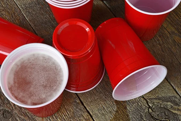 Görüntü kırmızı plastik bir kap ile eski bir çubuğu'nda dökülen bira kadar yakın bir tablo. 