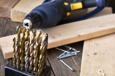 Görüntü matkap ve eski bir ahşap tezgah üzerinde mavi bir tatbikat yakından. 