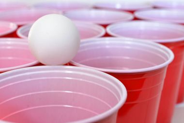 Görüntü kırmızı plastik içme bardak ve beyaz plastik ping pong topları yakından. 