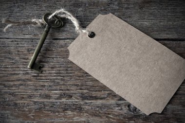 Eski bir ahşap masa üstü etiketinde antika bir anahtarla bir vintage tarzı görüntü. 