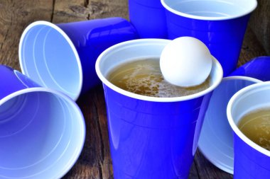 Bira eski ahşap masa görüntü mavi plastik bardak içme yakından dolu. 