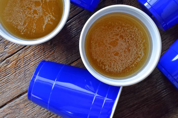 Uma Imagem Close Copos Plástico Azul Cheio Cerveja Uma Mesa — Fotografia de Stock