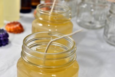 İş yapma küçük bir ev tabanlı mum için cam kalıplar içine dökülen erimiş mum balmumu görüntüsünü yakından. 