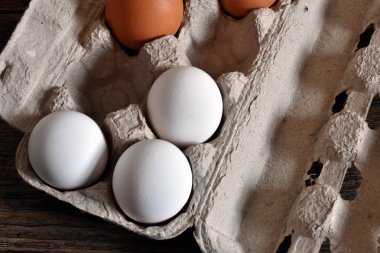 Resim rustik ahşap bir masa üzerinde bir kağıdı yumurta kartonu çiftlik taze organik yumurta yakından. 