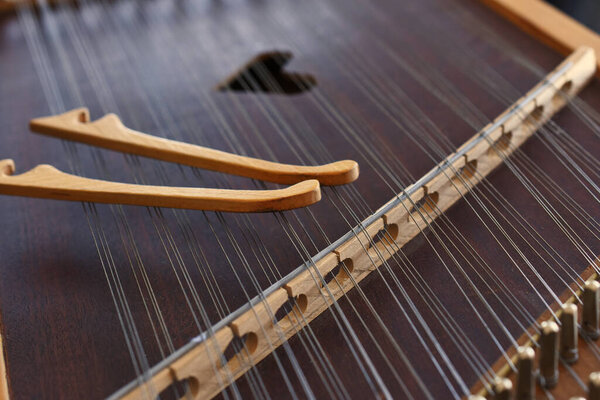 A close up image of the string on an old wooden Ukrainian Tsymbaly instrument.