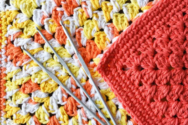 家庭製のかぎ針編みの布と金属製のかぎ針編みのフックのクローズアップ画像 — ストック写真