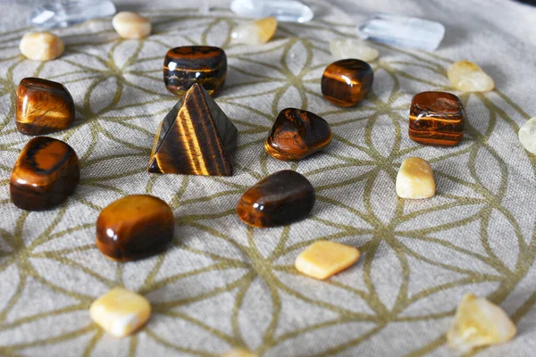 A close up image of a crystal prosperity grid using tigers eye and citrine crystals.