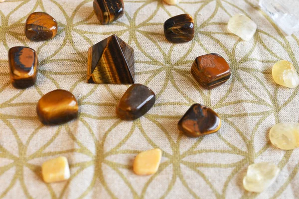 A close up image of a crystal prosperity grid using sacred geometry, tiger\'s eye, clear quartz, and citrine.