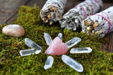 Bir gül kuvars kristal şifa ızgarası yakın plan görüntüsü leke çubukları ve reiki şifa sembolü ile yosun bir yatak üzerinde. 