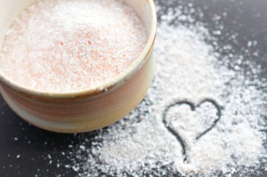 Açık renkli çanak çömlek içinde pembe Himalaya tuz kristallerinin yakın plan görüntüsü.. 