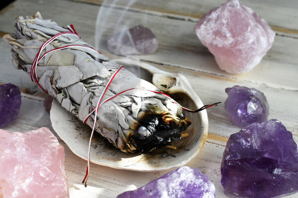 A close up image of a burning white sage smudge stick used for energy clearing and healing. 