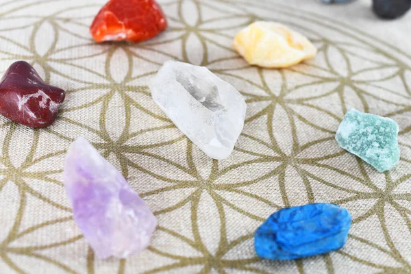 A close up image of chakra balancing crystals on a sacred geometry grid cloth.