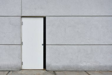 Ticari bir binanın üzerindeki büyük, koyu gri, çelik bir dış kapının görüntüsü.. 