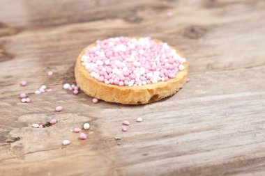 Geleneksel Hollanda doğum kutlama ahşap arka plan üzerinde pembe muisjes ile bisküvi