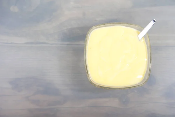 Ciotola di crema pasticcera alla vaniglia su fondo di legno — Foto Stock