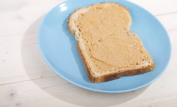 Хліб з арахісовим маслом на дерев'яному фоні — стокове фото