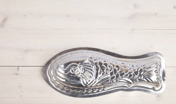 Molde de cozimento de peixe de prata no fundo de madeira — Fotografia de Stock