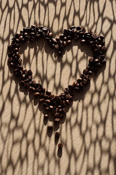 Kaffebönor i hjärta form med skuggor — Stockfoto