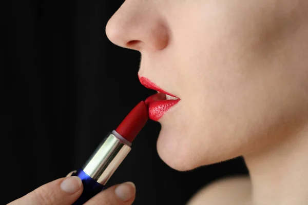 Meisje schildert lippen met lippenstift — Stockfoto