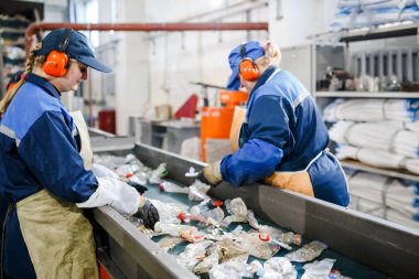 Minsk, Beyaz Rusya - 23 Aralık 2017: Kadın çalışmalarına üretim hattı Plastik atıkların işlenmesi için