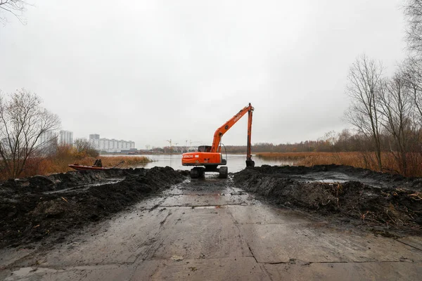 Mińsk, Białoruś - 1 października 2019: Koparka oczyszcza jezioro s — Zdjęcie stockowe