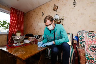 MINSK, BELARUS - 25 Şubat 2020: Sosyal hizmetler gönüllüsü yaşlı kadına Coronavirus 'a yardım etti