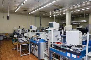 MINSK, BELARUS - 25 Şubat 2020: Electronics Factory Worker a Printed Circuit Board through a Digital Microscope High Tech Facity