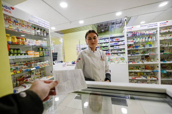 MINSK, BELARUS - 25 Şubat 2020: Bir gece eczanesinde eczacı