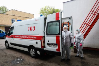 MINSK, BELARUS - 1 Mart 2020: Coronavirus 'tan ambulansı dezenfekte eden kadın