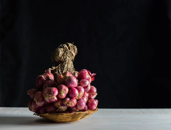 Sjalotten stilleven op witte tafel met zwarte achtergrond — Stockfoto