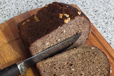 Bir parça kahverengi ekmek bıçak kesiyor