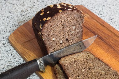 Bir parça kahverengi ekmek bıçak kesiyor