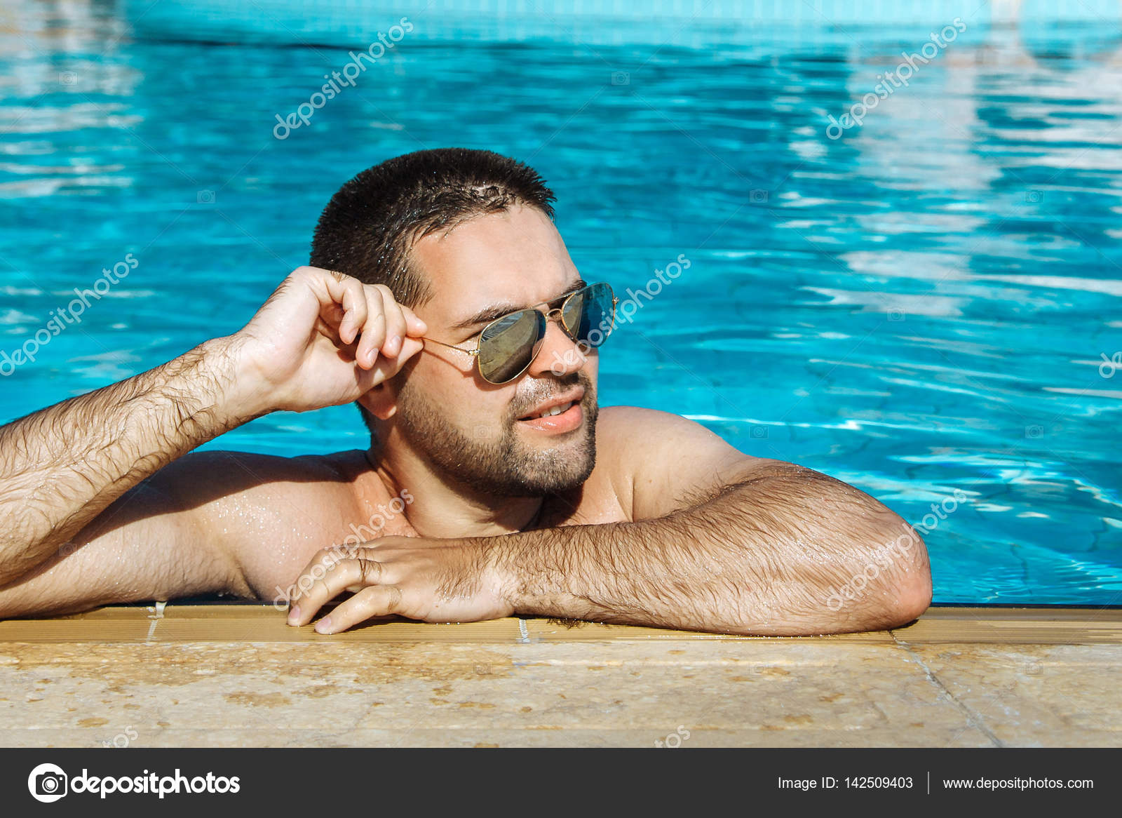 Young man in sunglasses resting relaxed on edge of swimming pool Stock  Photo by ©alex_kolechkin 142509403