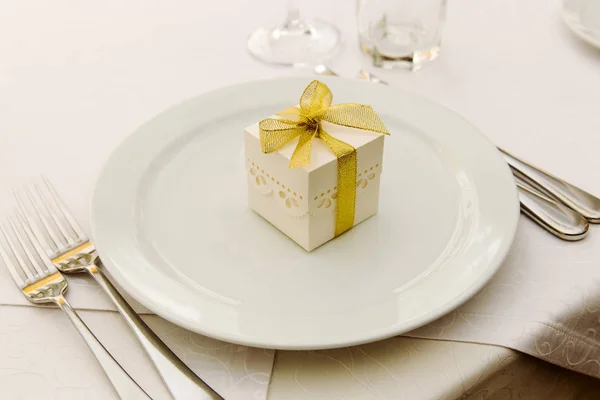 Bonbonnière de mariage avec ruban doré sur l'assiette — Photo