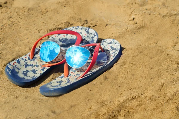 Chanclas y gafas de sol en la playa —  Fotos de Stock
