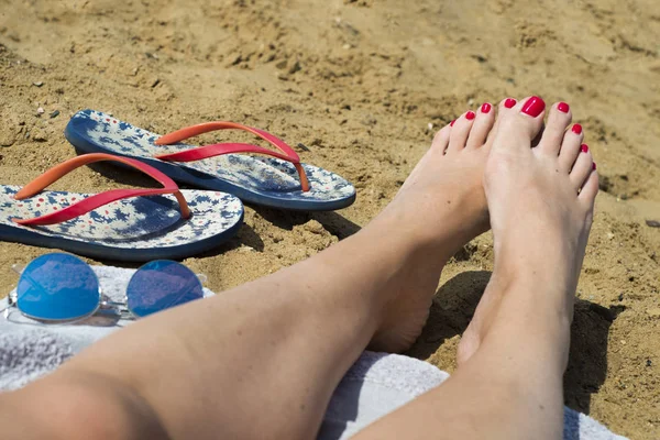 Joven chica piernas y chanclas en la playa de arena en Summe —  Fotos de Stock