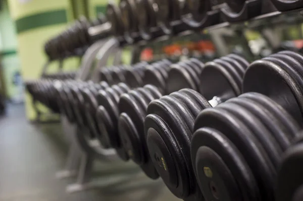 Rangées d'haltères dans la salle de gym — Photo