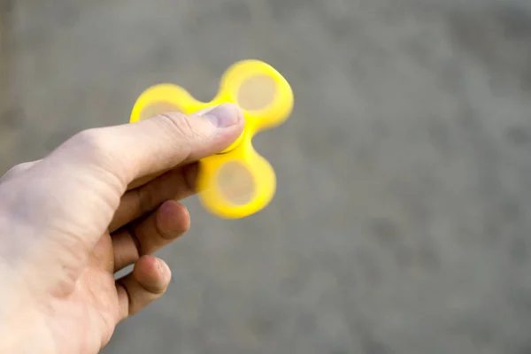 Man to play with Fidget Spinner in his hands, the concept of relieving stress, develop a small hand mathematics.