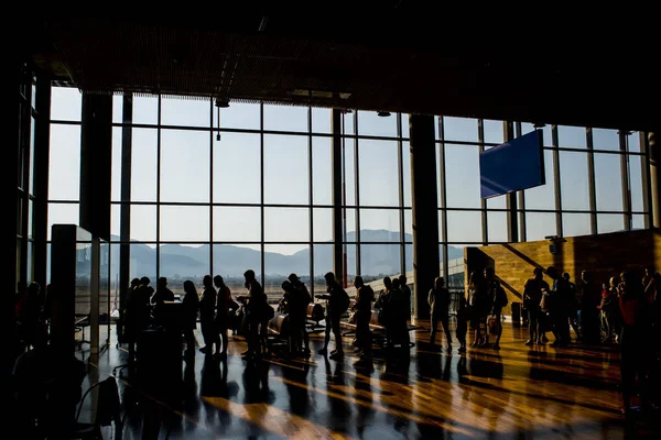 Silueta dav lidí čeká na letadlo v letištní terminál s hora b — Stock fotografie