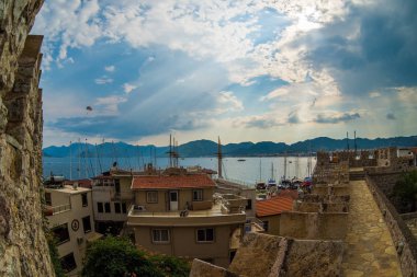 Havadan görünümü tekneleri ve Marmaris, Türkiye'de gün batımında güzel mimari. Renkli yatay, marina bay, deniz, şehir, dağlar tekneler. Liman yat ve yelkenli ile drone üzerinden Üstten Görünüm