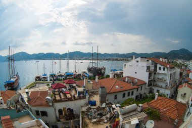 Havadan görünümü tekneleri ve Marmaris, Türkiye'de gün batımında güzel mimari. Renkli yatay, marina bay, deniz, şehir, dağlar tekneler. Liman yat ve yelkenli ile drone üzerinden Üstten Görünüm