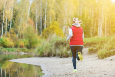 Bir kız ormanda gölün kıyısında çalışır.