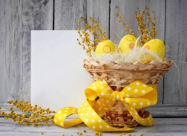 Žlutá velikonoční vajíčka v košíku — Stock fotografie