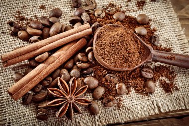 Kahve çekirdekleri, çekilmiş kahve ve tarçın çuval bezi üzerinde.