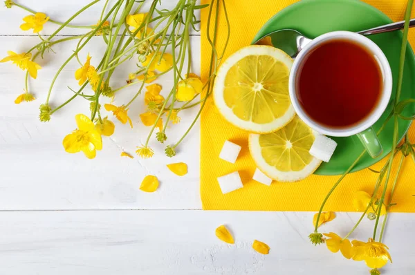 Fincan çay ve limon ile tahta masada vardır. — Stok fotoğraf