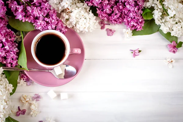 라일락의 분 지와 나무 테이블에서 커피 한 잔 정. — 스톡 사진