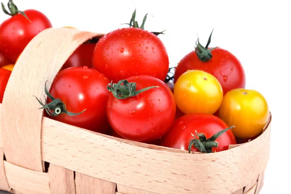 Tomates jaunes et rouges se trouvent dans le panier sur un fond blanc . — Photo