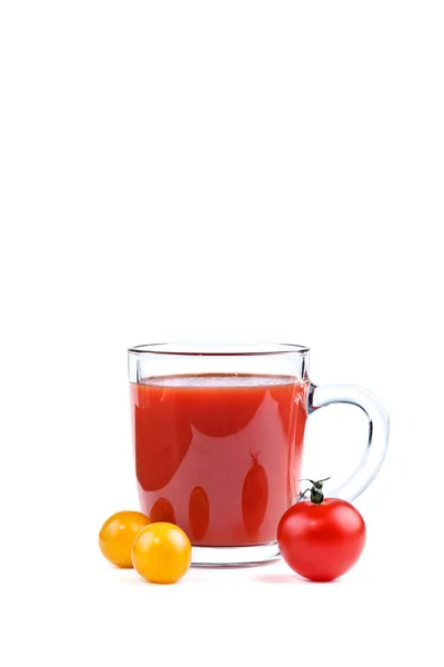 Un vaso de jugo de tomate y tomates rojos y amarillos sobre fondo blanco . — Foto de Stock