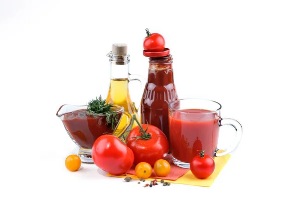 Zátiší z červených a žlutých rajčat, láhev rajčatovou omáčkou a olivový olej na bílém pozadí. — Stock fotografie
