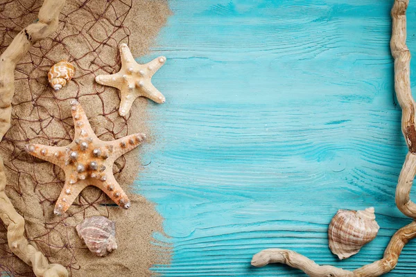 Estrella de mar, guijarros y conchas sobre un fondo azul de madera. Hay un lugar para las etiquetas . — Foto de Stock